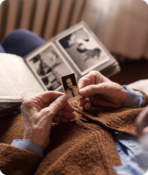 elderly person looking at a black white image of a man