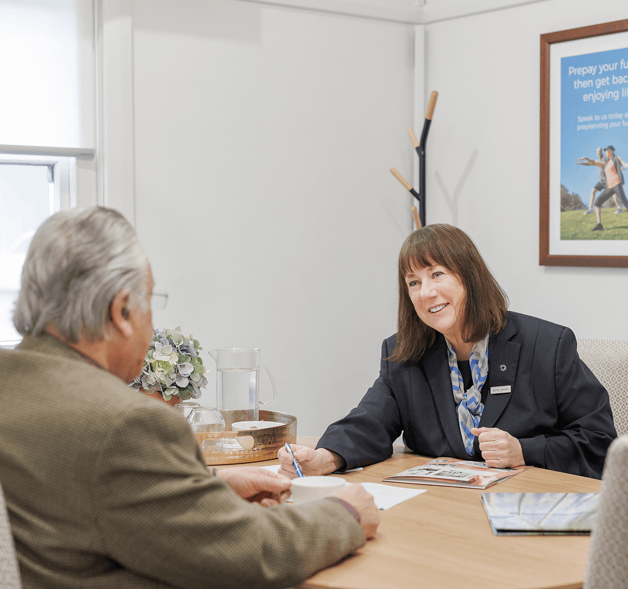 An image of a woman who is a funeral director discussing something with an older man.