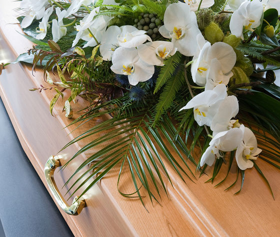 flower arrangement on top of coffin